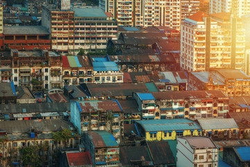 Fototapeta na wymiar 01/22/2020 Yangon, Myanmar (Burma), Aerial shot, view from the drone on the downtovn of Yangon with tiled and moss-covered houses at sunset pop colors. Yangon - the ancient capital of Burma
