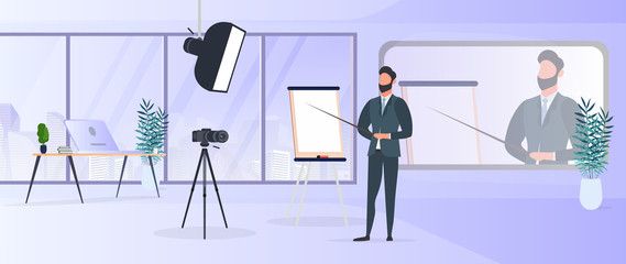 A man in a business suit with a tie is giving a presentation to the camera. The teacher is writing a lesson. The concept of blogging, online training and conferences. Camera on a tripod, softbox. 