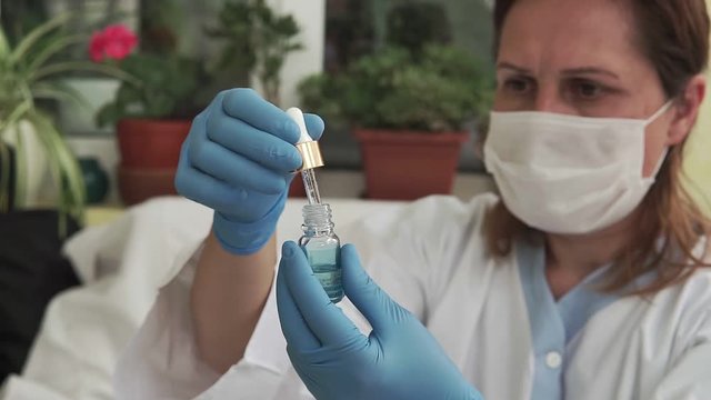 Researchers hand mixing solution from pipette in bottle at lab