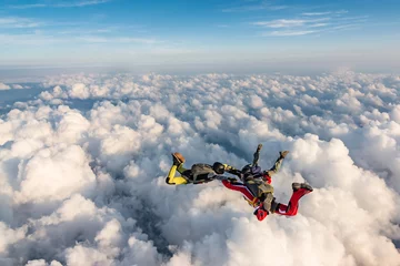 Fotobehang Bestsellers Sport Groep parachutisten boven de wolken.