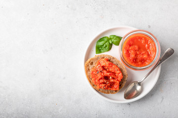 Balkan traditional dish ajvar in a glass on a light background. View from above, space for text, horizontal orientation