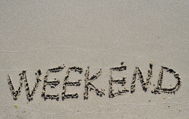 Weekend written on sand texture.
