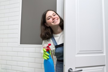 Fototapeta na wymiar Portrait of girl doing cleaning in bathroom