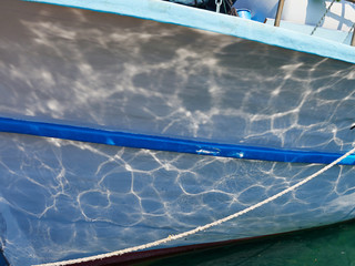 Gentle waves calm water reflected on a small boat