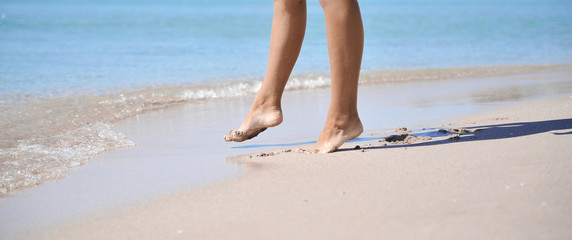 Female legs on sand texture.