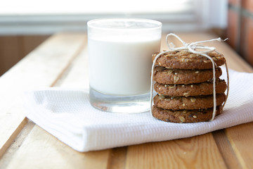 oatmeal cookies with a glass of milk on a wooden table