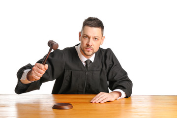 Strict male judge at table on white background