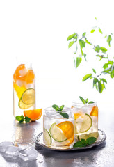 Lemonade or mojito cocktail with orange and mint, cold refreshing drink or beverage with ice