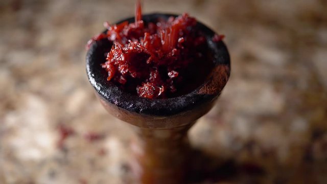 Hookah head being filled with nakhla double apple tobacco slow motion 