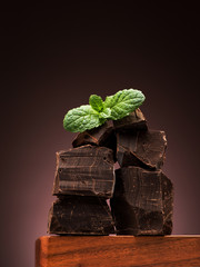 Closeup pieces dark chocolate on wooden board