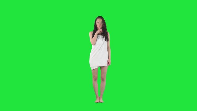 Sexy young woman in towel after shower with finger on lips slow motion. Secret or quiet. Full body pre keyed on green screen chroma key background