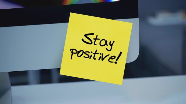 Stay positive. Sticky notes. The inscription on the sticker on the monitor. Message. Motivation. Reminder. Life motto in the workplace. Handwritten text written with a marker. Color sticker. 