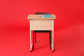 School desk with chair on color background