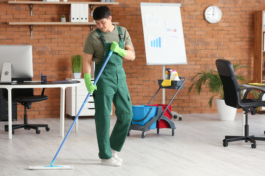 Male Janitor Mopping Floor In Office