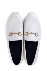 Men's lightweight shoes in fine white leather with an elegant metal buckle insulated against a white background with shadow. Top view.
