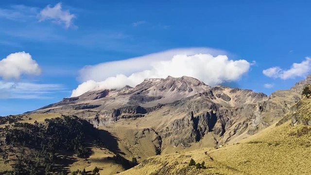 View of Iztaccihuatl mountain in Mexico with clouds rolling over the peaks