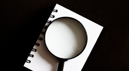 Opened old blank book with magnifying glass. . Empty place for text.