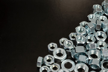 group of metal nuts close-up on a black background