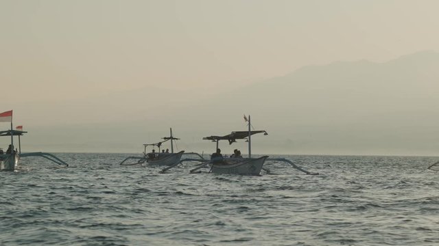 Asian white double-outrigger boats in blue waters. Windy weather