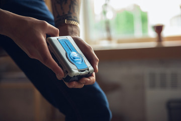 Portrait of millenial boy using retro toys, meeting things from the past and having fun. Generation of digital devices explores past entertainment. The memories of early childhood, again in trend.