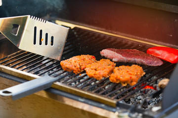 Barbecue and homemade food concept. Steak, red pepper and burger cutlet on grill. 