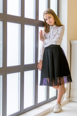 Fototapeta na wymiar Little girl posing in studio near a large panoramic window