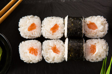 Set of sushi rolls with wasabi and ginger on a black background. Japanese oriental cuisine