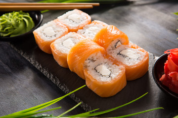 Set of sushi rolls with wasabi and ginger on a black background. Japanese oriental cuisine