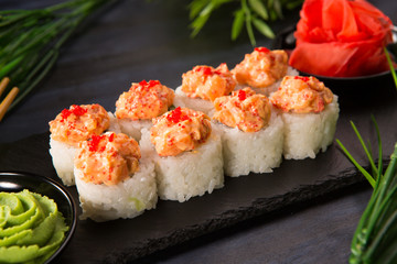 Set of sushi rolls with wasabi and ginger on a black background. Japanese oriental cuisine