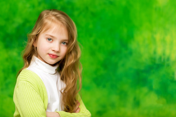 Close-up, on a green background portrait of a beautiful little g