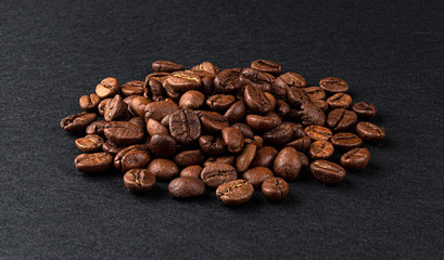 Heap of roasted coffee beans on black background