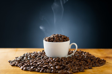 Roasted coffee beans in coffee cup.
Delicious coffee concept image.