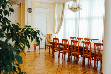 large table with chairs in the interior of a white room with a window