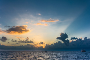 Tramonto tra le nuvole tra gli atolli del mare delle Maldive