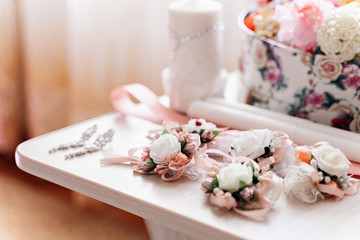 White-pink wedding decorations of roses lie on a table with earrings