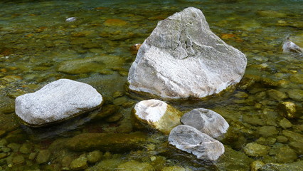 ausgewaschene Steine im kristallklaren Fluss, Nahaufnahme, Hintergrund