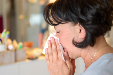 Woman blowing her nose on a tissue