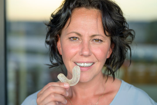 Attractive Smiling Woman Holding A Mouth Guard