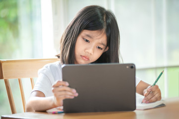 Asian girl is studying online at home with tablet  Showing a face do not understand the teaching and learning content