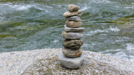 Steinmännchen auf Felsen und im Hintergrund der  Fluss