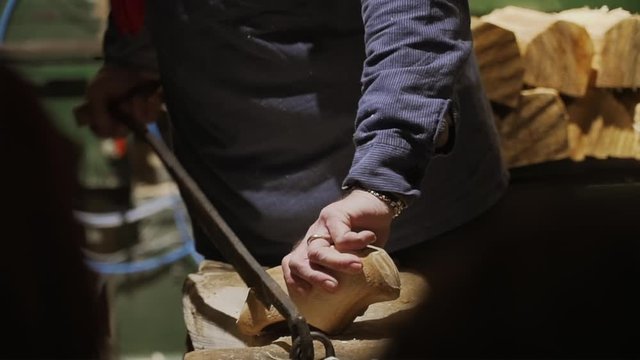 A close-up shot of a traditional Dutch Clog maker carving and shaping a wooden Clog by hand in Amsterdam, Netherlands