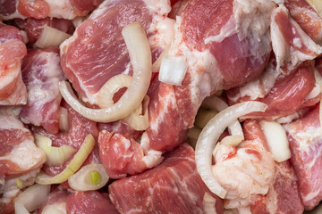 Pork meat marinated for grill in onion, herbs and spices. Shashlik background. .