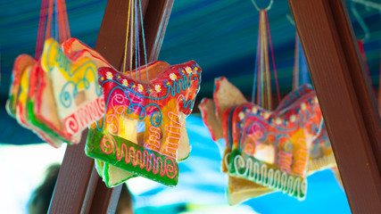 Gingerbread in the shape of a horse hanging below the festivals tent. Sweets in bags at a street sale.