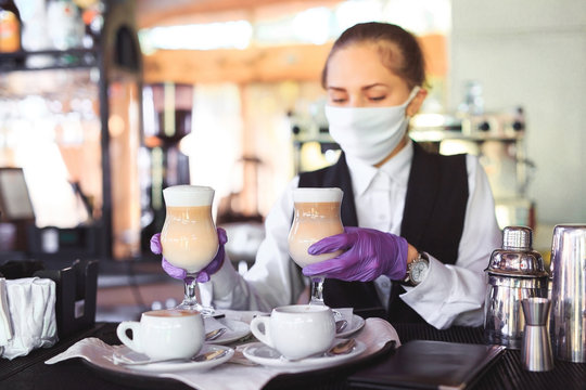 bartender in medical mask and gloves makes latte coffee.