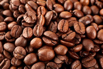 Roasted coffee beans on a white background. The texture of the coffee. An invigorating drink.