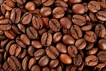 Roasted coffee beans on a white background. The texture of the coffee. An invigorating drink.