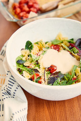 High angle view of pasta salad with mayonnaise near napkin on wooden background