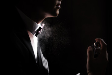 the image of a man's profile, the man sprays perfume on herself Squirting on the neck