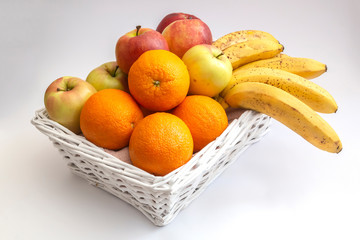 Fruit basket with apples, bananas and oranges