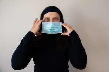 A woman is trying to hide traces of domestic violence by wearing a medical mask. The concept of rising domestic violence during quarantine isolation COVID-19.